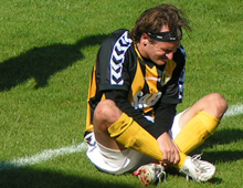 Jesper Duelund, Brønshøj, sidder på banen og ømmer sig efter en hård tackling i hjemmekampen mod HIK lørdag 16. august 2008 (foto: T. Brygger)