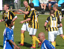 Brønshøjs spillere jubler efter scoring mod Holbæk, hvis angriber Ake/Akida ser til (foto: T. Brygger)