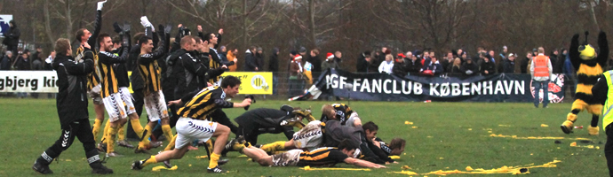 Brønshøjs spillere jubler over for Tingbjerg-publikken mens AGFs fanclub i baggrunden pakker deres banner sammen efter Brønshøjs hjemmesejr over AGF 21. november 2010 (foto: L. van Rensburg)