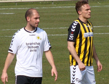 Brønshøjs Pierre Kanstrup (th) og Hobros Svenne Poulsen i de to holds uafgjorte kamp på Tingbjerg 21. april 2012. Begge spillere er iklædt Brønshøj-trøjer, da Hobro måtte spille i Hvepsenes hvide udebanetrøjer. Foto: T. Brygger.