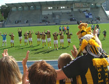 Vue fra Brønshøjtilskuerpladserne ud mod banen og jublende Brønshøjspillere efter Hvepsenes meriterende udesejr over B 93 23. august 2009 (foto: S. Lillie)