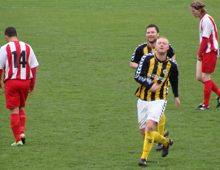 Patrick Tronborg og Michael Jørgensen, Brønshøj Boldklub, i jubel over førstnævntes scoring til 3-0 i overtiden i udekampen mod Glostrup-Albertslund 8. maj 2010. I baggrunden lusker slukørede spillere fra hjemmeholdet rundt. (foto: T. Brygger)