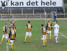 Brønshøjs Thomas Christiansen, Mads Frost, Jacob Josephsen, Patrick Tronborg, Peter Larsen, Michael Jørgensen, Nicklas Elver Granzow og Kim Drejs i Nykøbing Falster under det meget sigende reklameskilt med teksten "Vi kan det hele" (foto: T. Brygger)